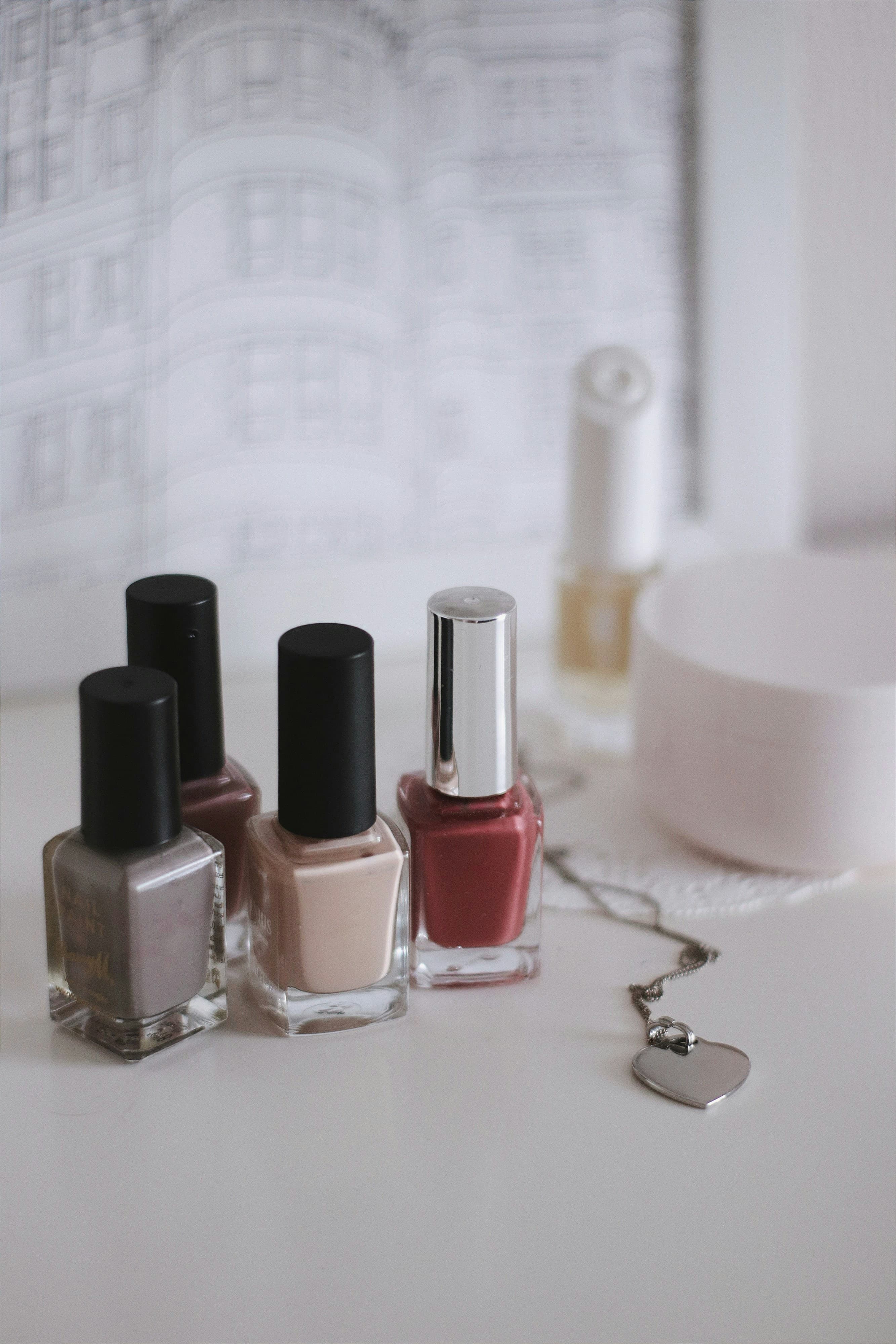 Pink and black nail polish bottles arranged on a neutral surface