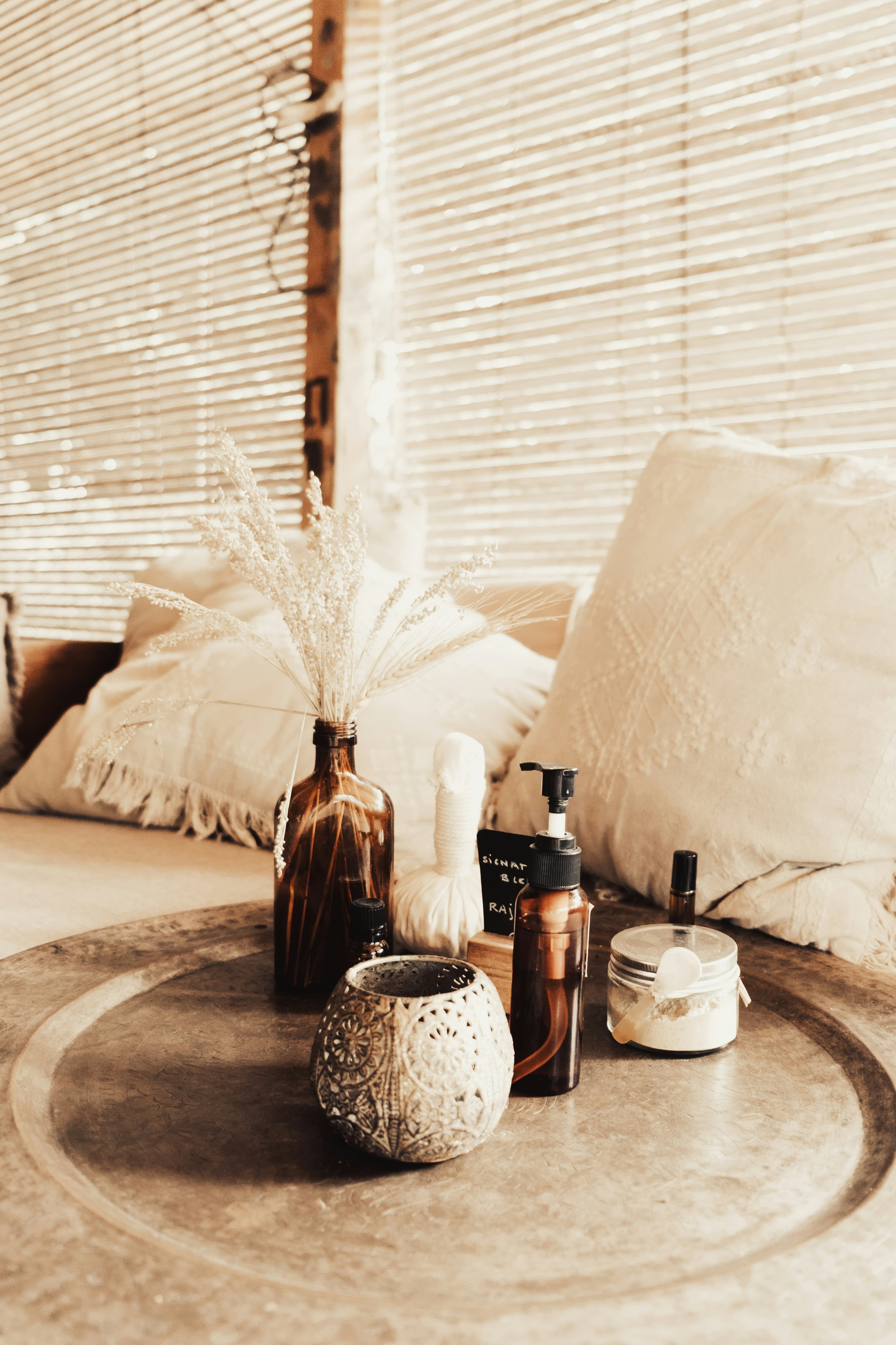 A table with bottles and a vase of fresh flowers